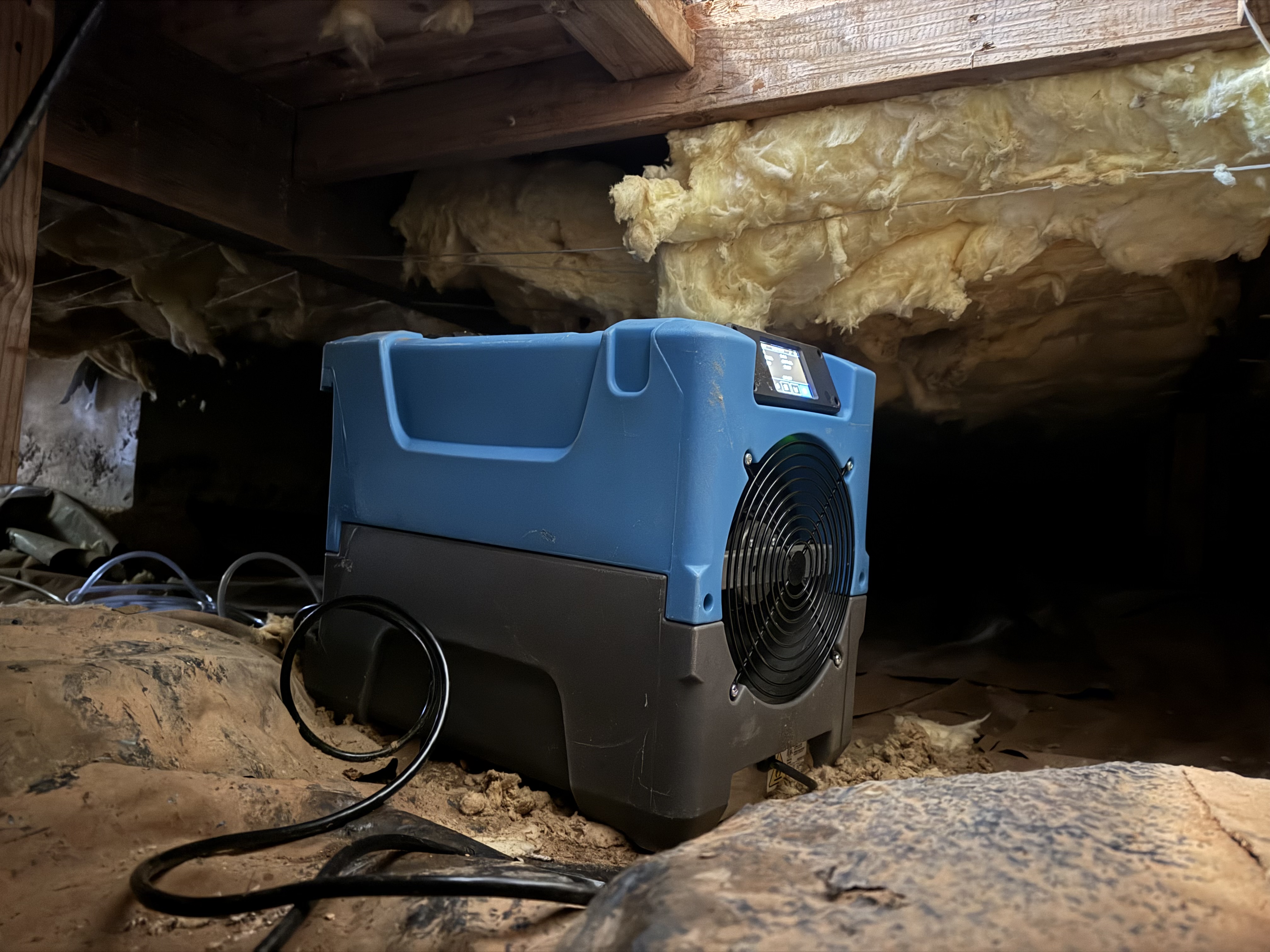 Dehumidifier in crawl space with exposed insulation