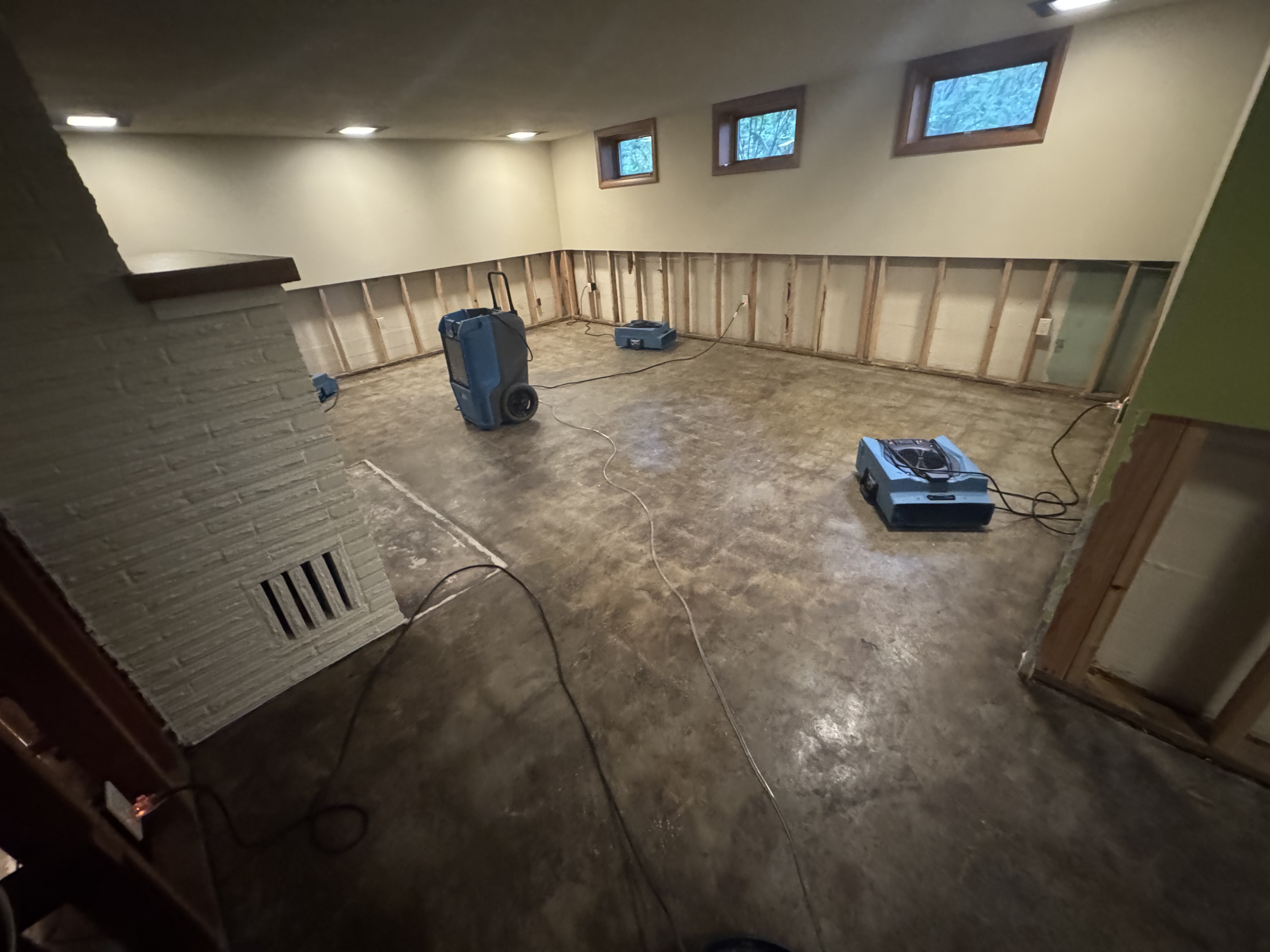 Basement water damage restoration with multiple dehumidifiers and air movers