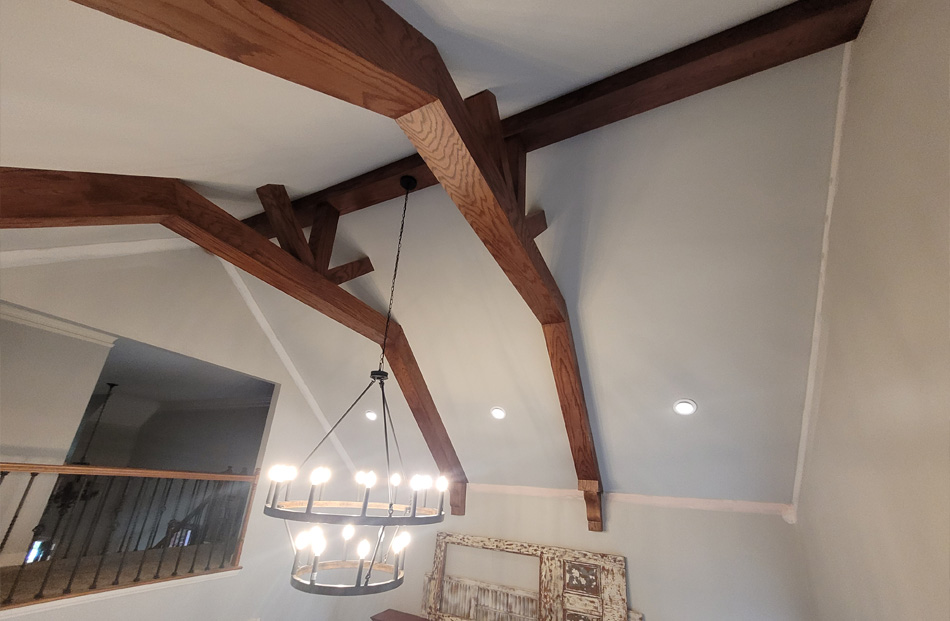 Wooden beams and chandelier in modern home interior.