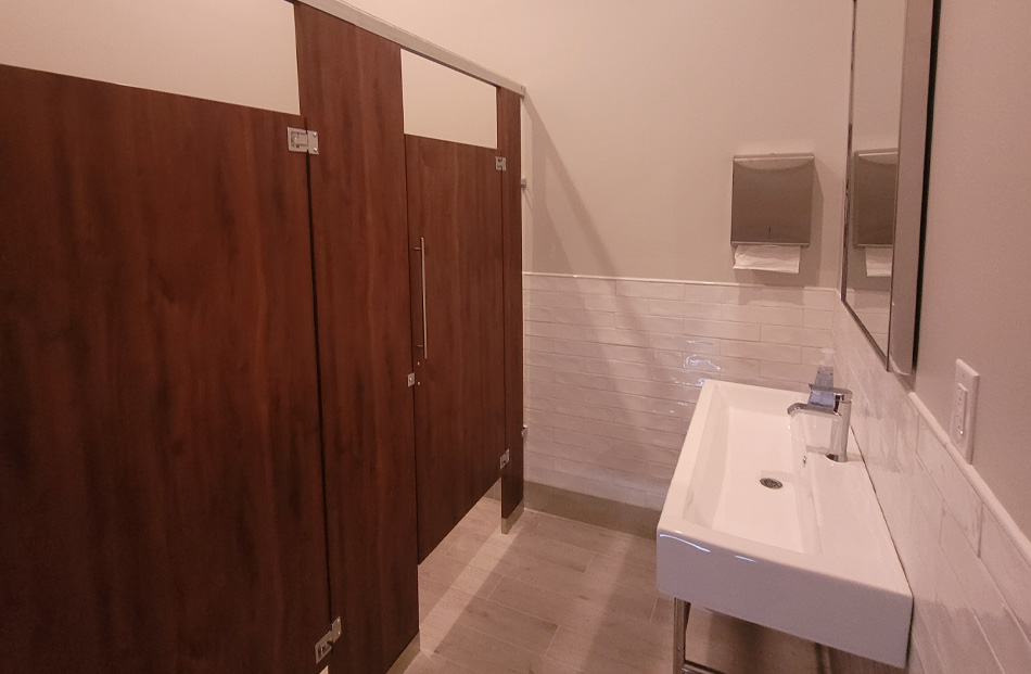 Modern public bathroom with wooden doors and white sink.
