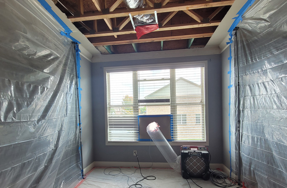 Room under renovation with exposed ceiling and covered walls.