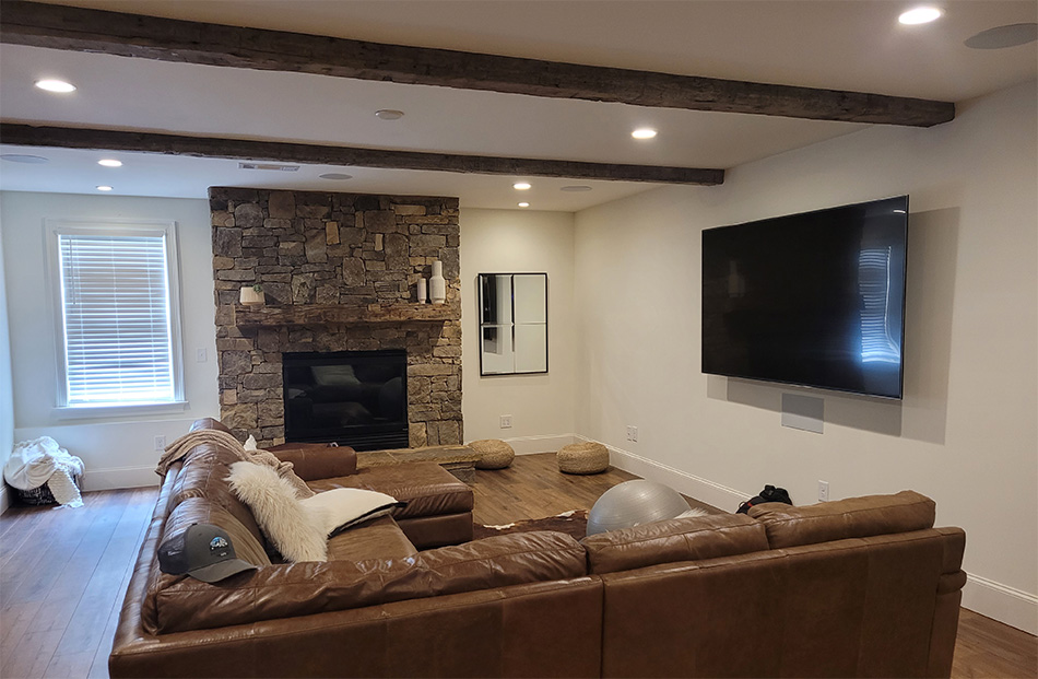 Modern living room with stone fireplace and wooden beams.