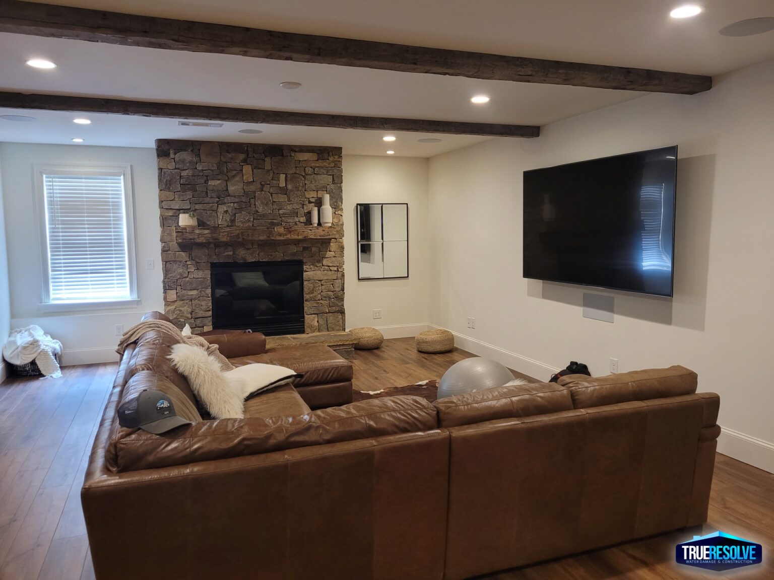 Cozy living room with stone fireplace and mounted TV.